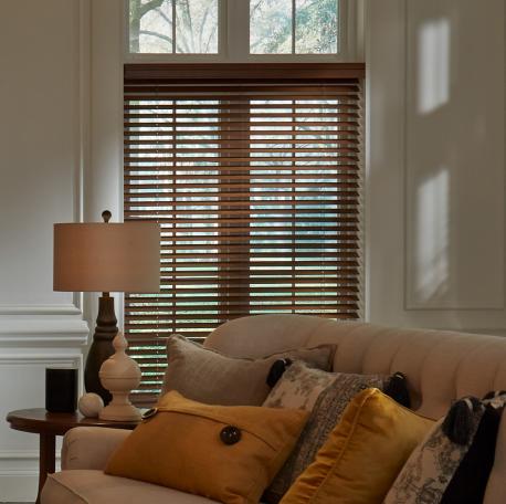 Lutron Serena wood blinds with automated tilt in cozy living room with leather sofa